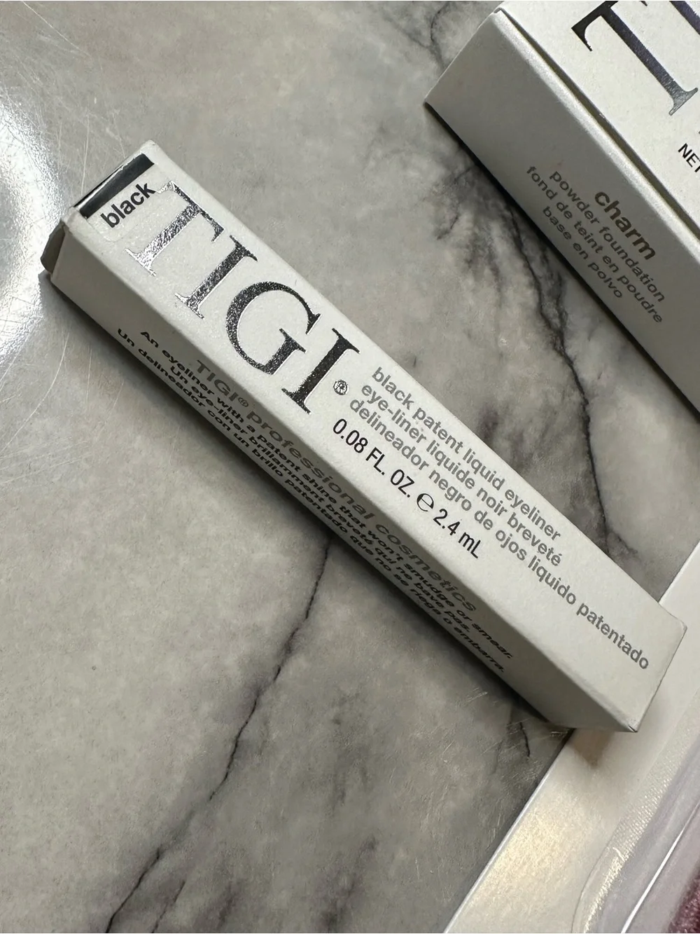 TIGI Bronzer Compact, liquid eyeliner, and blush brush.